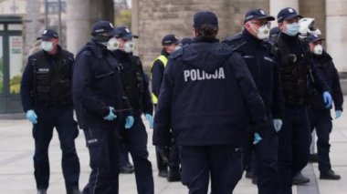 Varşova, Polonya 04.15.2020 - Girişimcilerin protestosu, sokağa çıkma yasağı saatlerinde Varşova 'da yüzleri maskeli birçok polis memuru