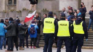 Varşova, Polonya 04.15.2020 - Girişimcilerin protestosu, sokağa çıkma yasağı saatlerinde Varşova 'da yüzleri maskeli birçok polis memuru