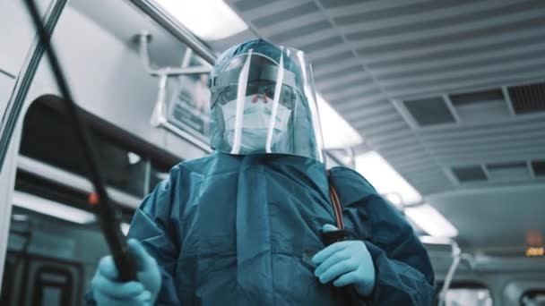 Portrait of an african worker with protective suit, face shield and medical mask disinfecting train — Stock Video