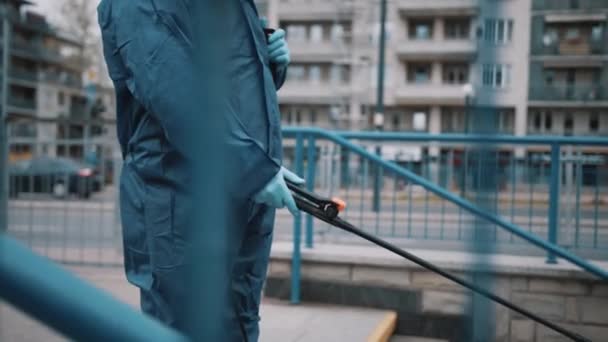 Hombre africano con equipo de protección personal NBC desinfecta escaleras en un lugar público — Vídeo de stock