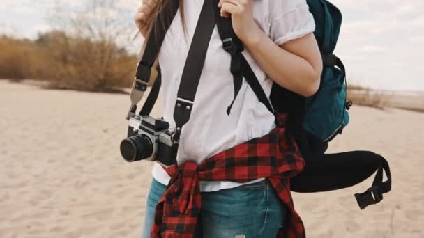 Jonge vrouw backpacker wandelen langs het zandstrand. close-up volgen slow motion schot — Stockvideo