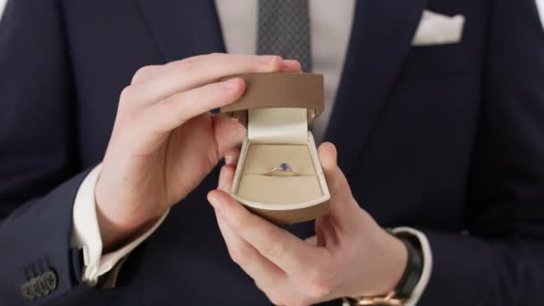 Novio sosteniendo un anillo de boda — Vídeos de Stock