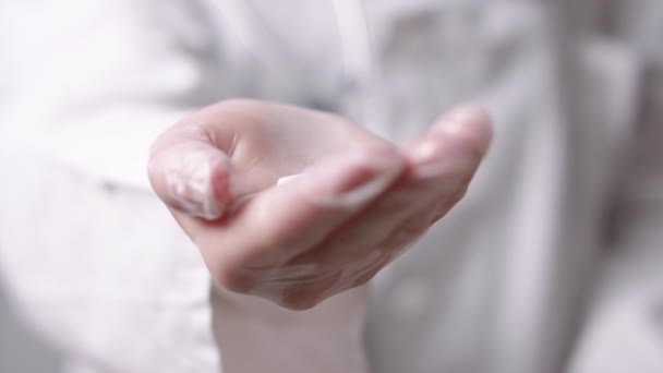 De perto, médico segurando comprimidos brancos na mão com a luva. Medicação e cura para a gripe — Vídeo de Stock