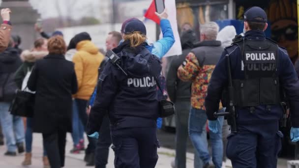 Varsovia, Polonia 04.15.2020 - Protesta de empresarios, joven agente de policía grabando protesta. con máscara protectora en la multitud de la gente en medio del toque de queda — Vídeos de Stock