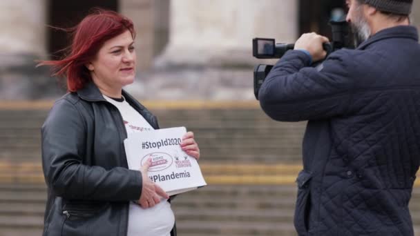 Varsovia, Polonia, 04.15.2020 - Protesta de los empresarios, mujer dando una entrevista con el lema, detener ID2020 y el hashtag plandémico — Vídeos de Stock