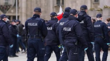 Varşova, Polonya 04.15.2020 - Girişimcilerin protestosu, sokağa çıkma yasağı saatlerinde Varşova 'da yüzleri maskeli birçok polis memuru
