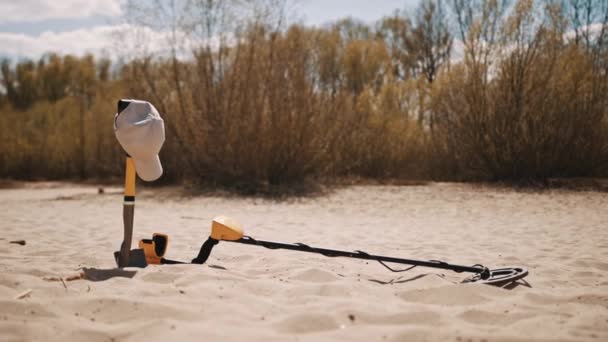 Gereedschap voor het opsporen en graven van verloren gegane edelmetalen op het zand. Hoed op de schop — Stockvideo