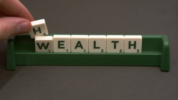 ワルシャワ、ポーランド｜04.01.2020健康は富の概念です。文字のタイルで富の代わりに健康を綴る人 — ストック動画