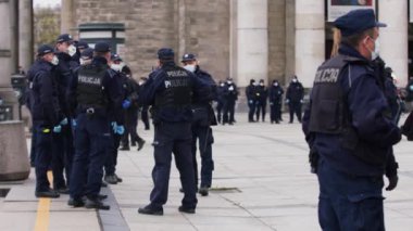 Varşova, Polonya 04.15.2020 - Girişimcilerin protestosu, sokağa çıkma yasağı saatlerinde Varşova 'da yüzleri maskeli birçok polis memuru