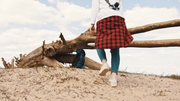 Ung oigenkännlig kvinna som går på sanden och hämtar sin ryggsäck. slow motion låg vinkel skott — Stockvideo