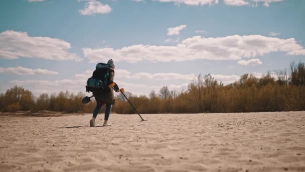 Persona irriconoscibile che scansiona la sabbia con metal detector per trovare metalli preziosi . — Video Stock