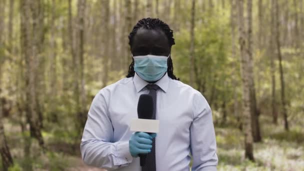 Afrikansk journalist med medicinsk mask gör en intervju — Stockvideo