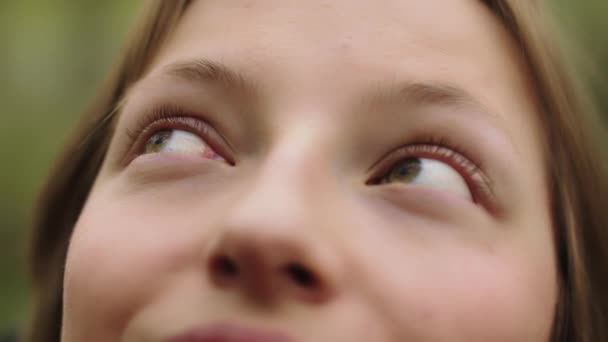 女性の顔を閉じて、女の子は彼女の美しい青い紺碧の目を開き、公園を見て回る。スローモーション — ストック動画