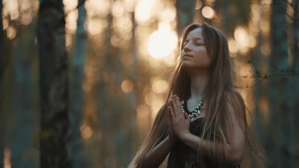 Молодая духовная женщина занимается йогой на рассвете в лесу — стоковое видео