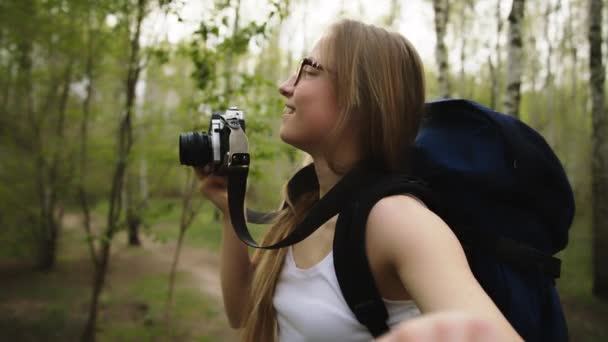 Emocionada joven turista con mochila con cámara vintage y mano de su novio en el bosque — Vídeo de stock