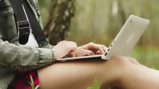 Закрывай. Неузнаваемая женщина использует ноутбук в природе. Дистанционное обучение или дистанционное обучение — стоковое видео