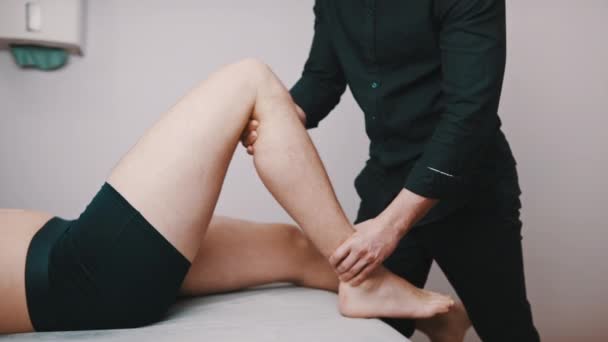 Fisioterapia. Técnico inspeccionando la flexibilidad de la rodilla. Asistencia sanitaria y recuperación — Vídeo de stock