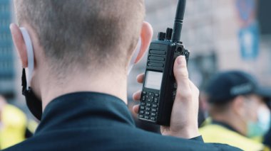 Varşova, Polonya, 05.07.2020 - Girişimcilerin protestosu, gösteriler sırasında telsiz veya polis telsizi kullanan memur