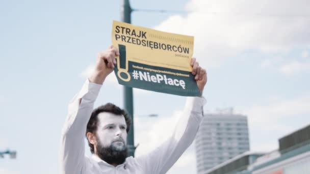 Varšava, Polsko, 05.07.2020. Protest proti podnikatelům. Pouliční umělec s namalovanou tváří v bílém, držící protest transparentní — Stock video