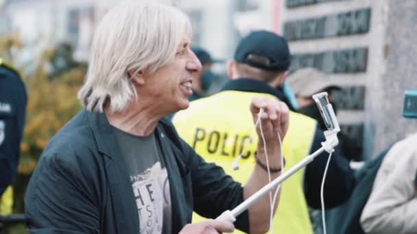 ワルシャワ、ポーランド、 05.07.2020 。-起業家の抗議。男はヘッドフォンマイクで話すスマートフォンでライブに行く — ストック動画