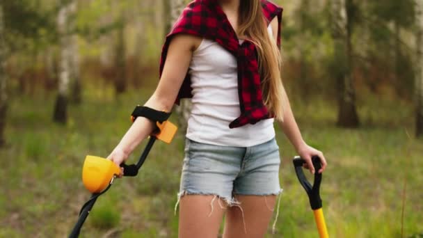 Jeune femme fouillant la forêt avec le détecteur de métaux. Je cherche les métaux précieux perdus. Tilting up shot — Video