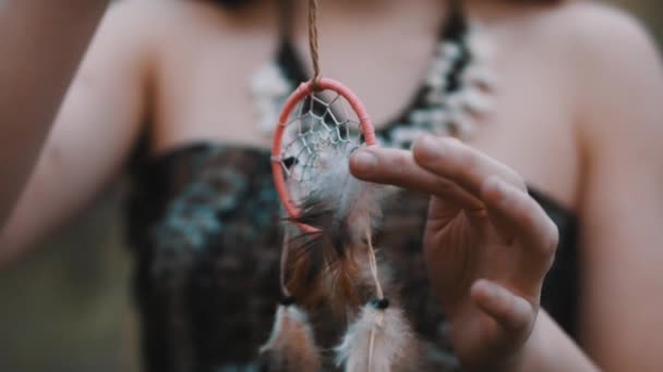 Joven mujer girando el atrapasueños. De cerca. Espiritualidad y conexión con el concepto de naturaleza . — Vídeo de stock