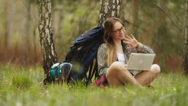 Молодая кавказка-путешественница, отдыхая в лесу, получила видеозвонок на свой ноутбук — стоковое видео