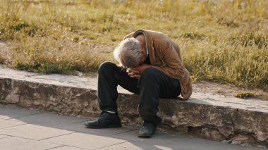 Varşova, Polad, 05.16.2020 - Umutsuz ve evsiz insan sokakta oturuyor ve ağlıyor