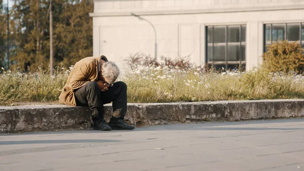 Varsovia, Polonia 05.16.2020. - Hombre sin esperanza y sin hogar con la cabeza doblada sentado en la calle — Foto de Stock