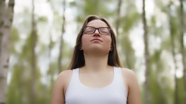 Portret van gelukkige jonge blanke vrouw met bril, toeristen genieten van frisse lucht en zonnestralen in het park. — Stockvideo