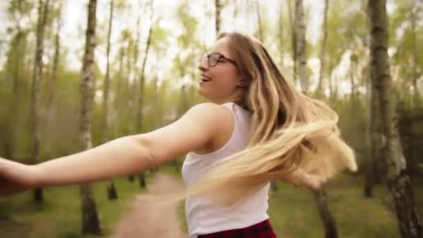 Hermosa mujer caucásica joven feliz girando en el bosque. Concepto de libertad — Vídeo de stock