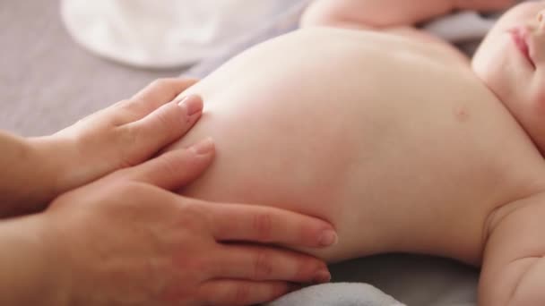 Madre masajeando la barriga del bebé. Cuidado de la piel del bebé y concepto de desarrollo — Vídeo de stock