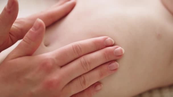 Madre masajeando la barriga del bebé. Cuidado y desarrollo de la piel del bebé . — Vídeo de stock