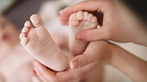 Мама играет с детскими ножками. Растяжка и упражнения для концепции развития ребенка
