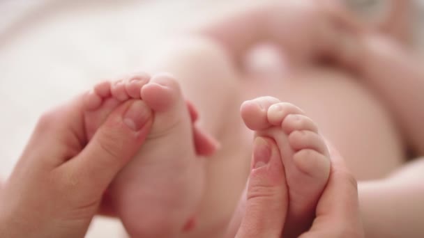 Mãe brincando com os pés de bebê. Alongamento e exercícios para o conceito de desenvolvimento do bebê — Vídeo de Stock