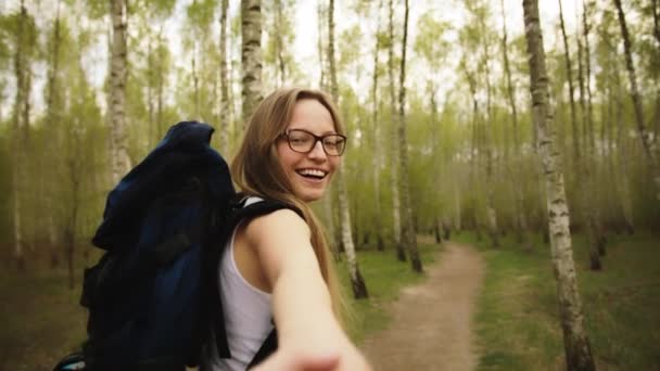 Boldog fiatal kaukázusi nő vezeti a barátját az erdőbe. Utazó pár szerelmes kéz a kézben a természetben — Stock videók