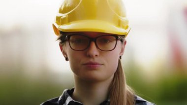 Genç kadın, sarı şapkalı mühendis. Portre, yavaş çekim ve sığ alan derinliği