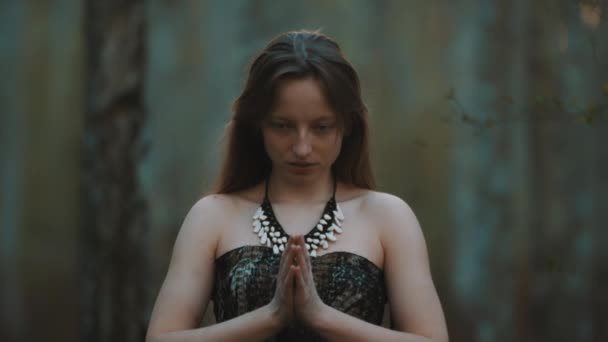 Jonge blanke vrouw beoefent yoga of mediteert in het bos. Verbinding met de natuur — Stockvideo