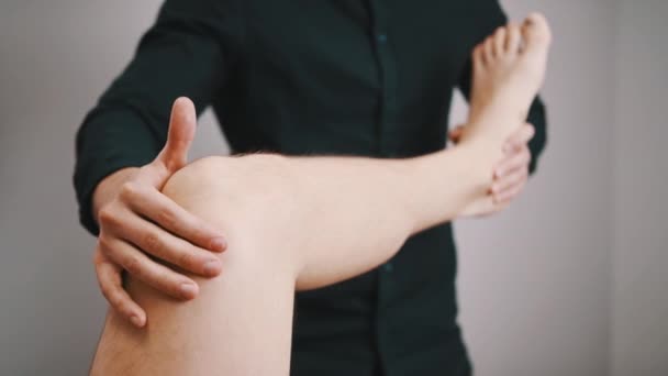 Terapeuta inspecionando a flexibilidade do joelho. Conceito de fisioterapia esportiva — Vídeo de Stock