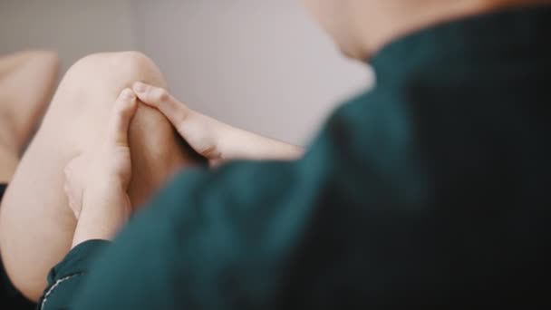 Therapeut inspecteert de knieflexibiliteit. Sport fysiotherapie concept — Stockvideo