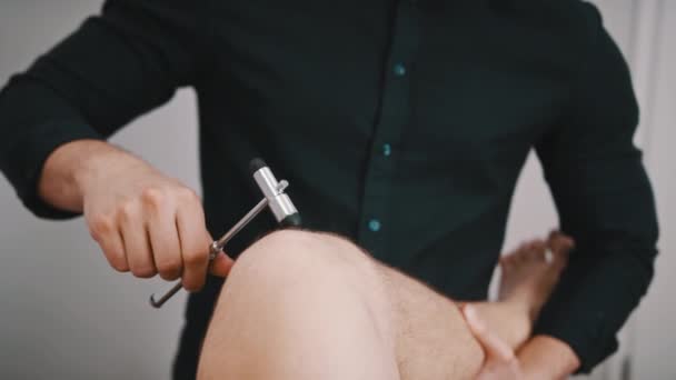 Chiropractic treatment - Doctor specialist testing out the reaction on medical hammer on a knee — Stock Video