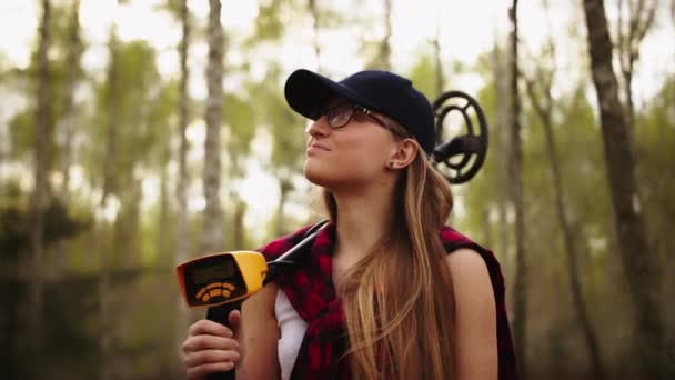 Mujer joven exploradora en el bosque con el detector de metales en su espadachín — Vídeo de stock