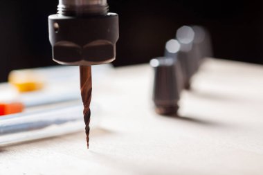 Tahta bir yüzey üzerinde bir cnc router değirmeni ile spindle, kutular içinde üç değirmen kesiciler ve üç kolej