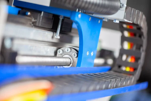 Siyahlı CNC makinesinin kablo rehberleri. Arka planda top vida vagonu var.