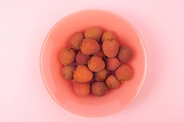 Несколько Плодов Личи Лежат Коралловой Тарелке Розовом Фоне — стоковое фото