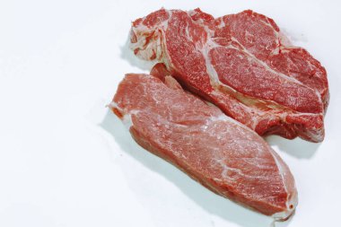 Beyaz arka planda çiğ et ve domuz bifteği izole edilmiş.