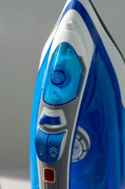 Mavi ve beyaz elektrikli demir yakın plan. Buhar düğmeleri