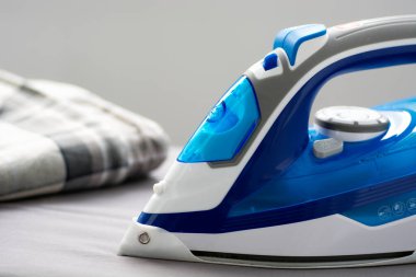 İş yüzeyinde koruyucu silikon pedi olan elektrikli demir. Yaklaş.