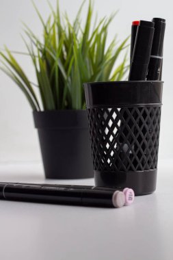 Ofis camındaki siyah işaretler ve yapay bir bitkinin arka planında duran siyah işaretler..