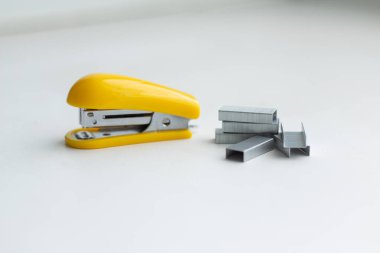 Beyaz arka planda sarı küçük zımba. Zımba zımbaları yakınlarda..